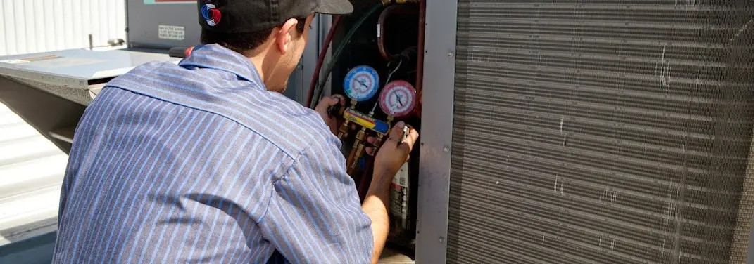 HVAC technician servicing a condenser unit in Arcadia