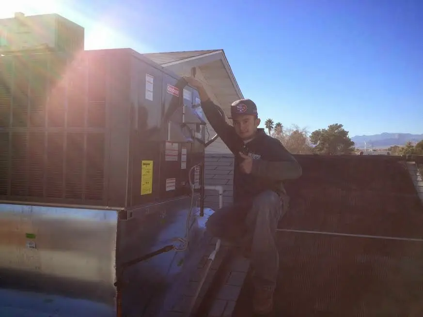 HVAC technician performing Heat Pump Repair on a rooftop unit in Arcadia